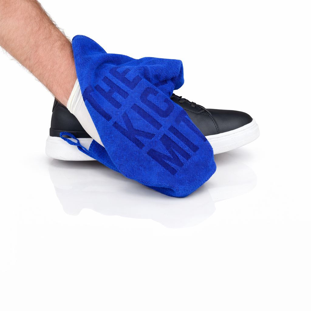 Blue towel with text on a black and white sneaker against a white background